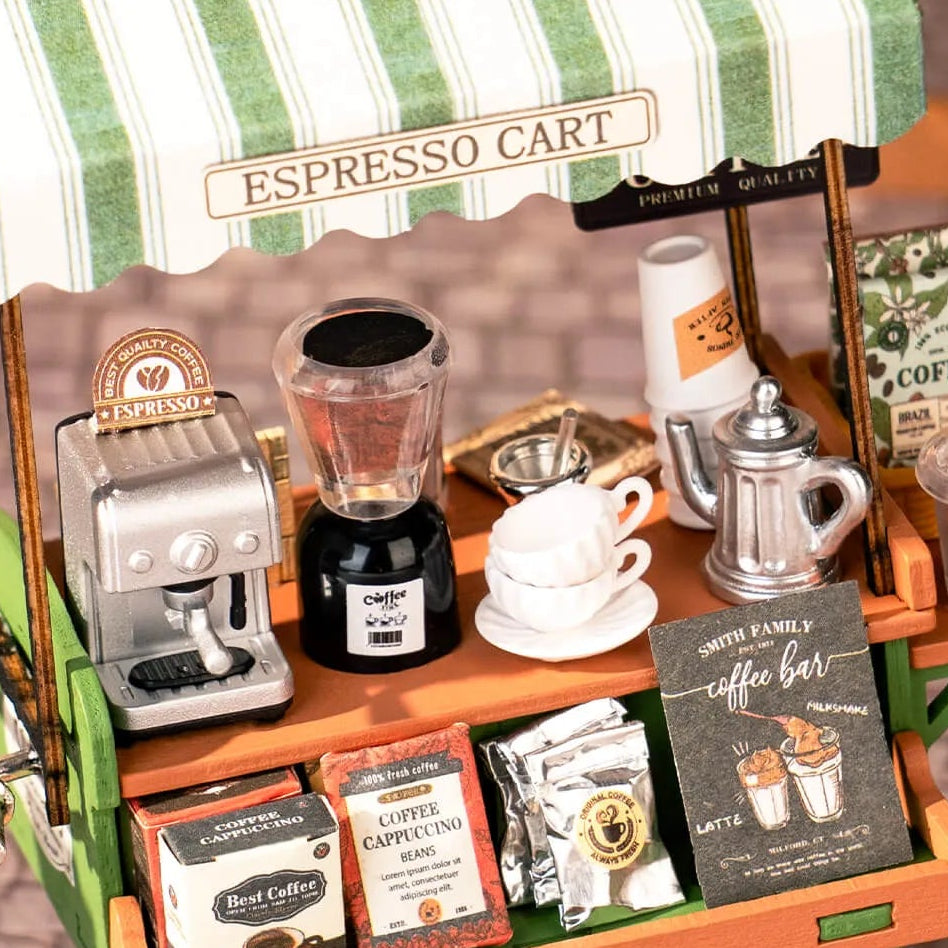 Miniature espresso cart with coffee-themed products and accessories on a green and white striped canopy.