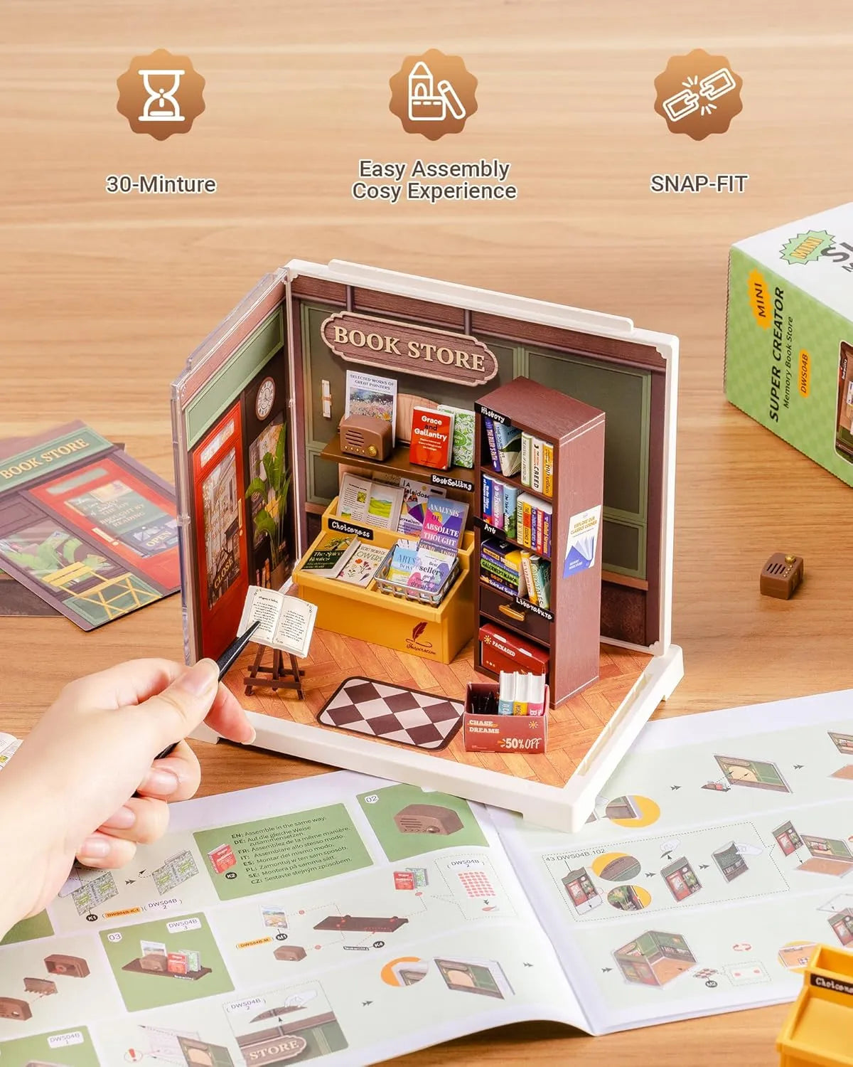 Miniature book store model with assembly instructions on a wooden surface